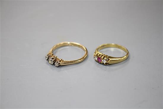 A modern 18ct gold, ruby and diamond set three stone ring and an 18ct and three stone diamond ring,